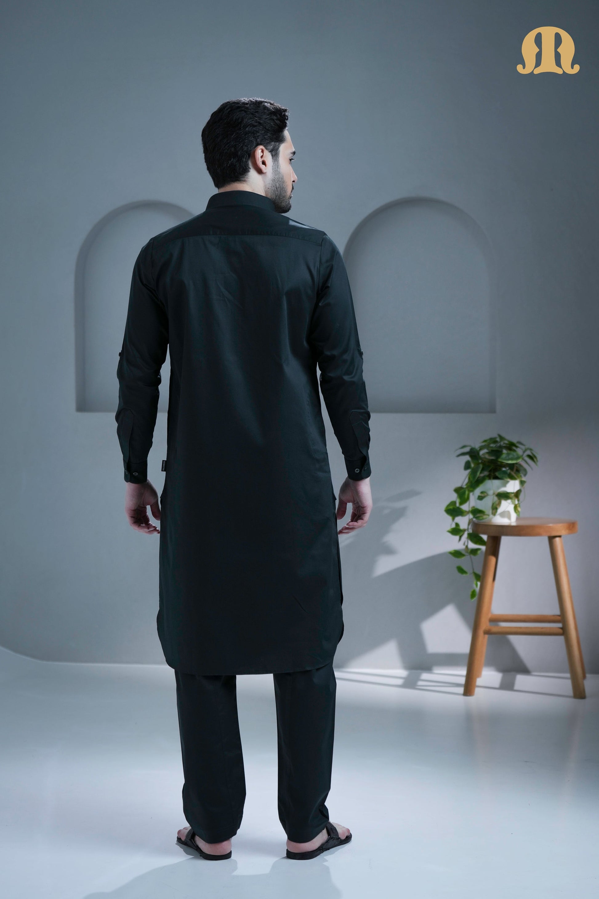 Side profile of the men's dark green cotton Pathani suit.