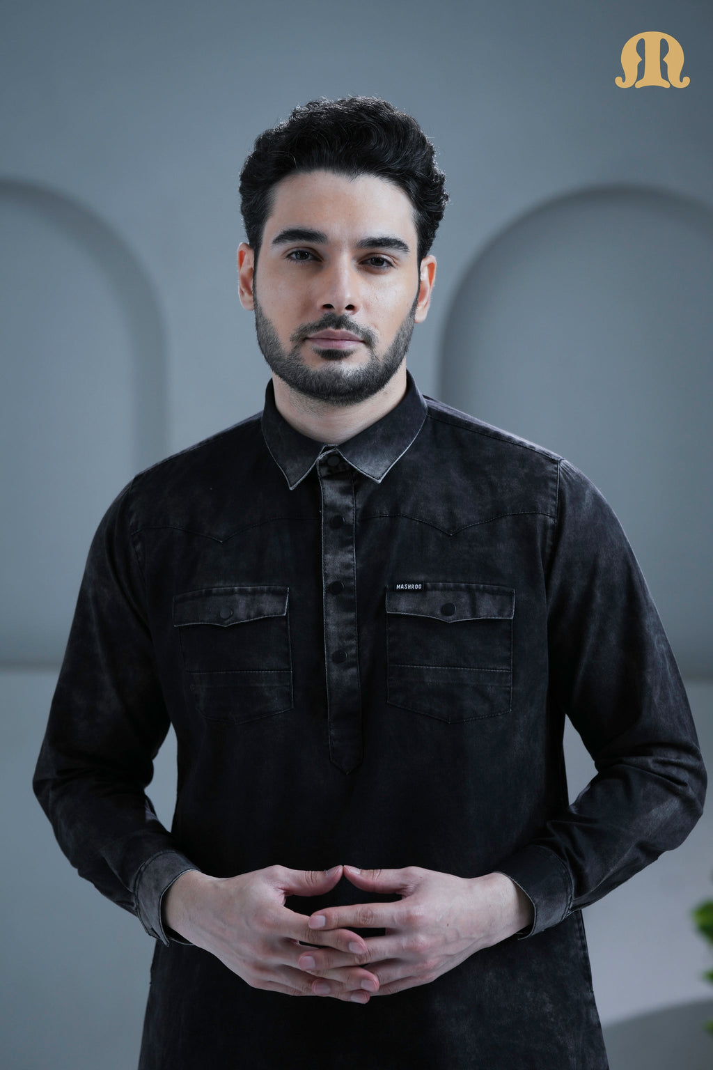 Detailed view of the placket and stitching on the Mashroo black denim thobe.
