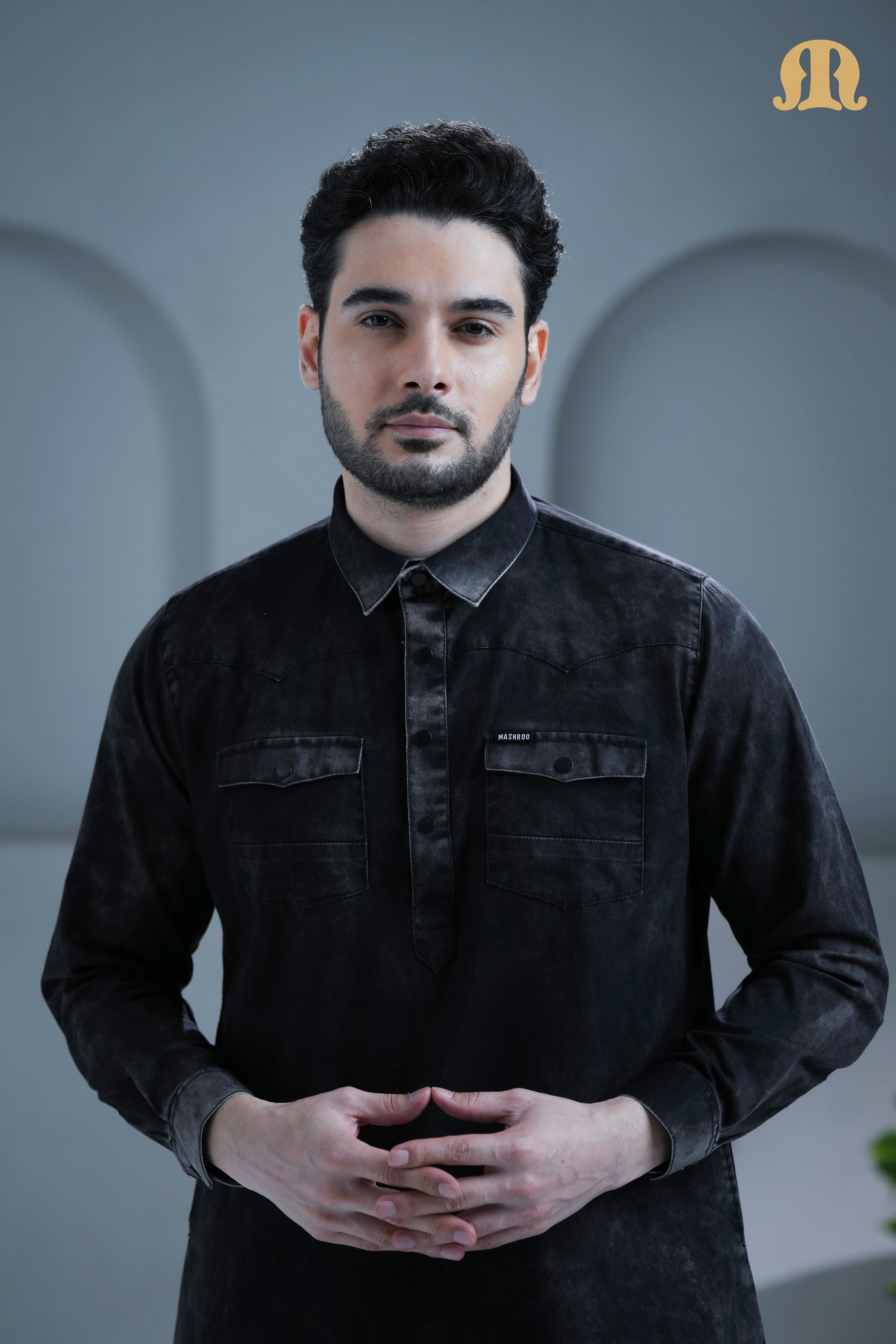 Detailed view of the placket and stitching on the Mashroo black denim thobe.
