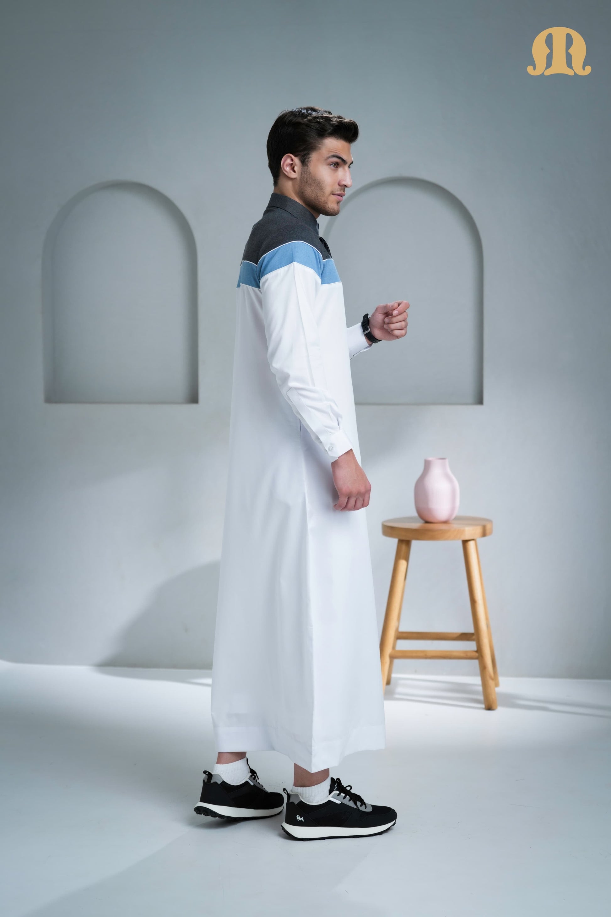 Side profile of the men's Belloumi Thobe showcasing its modern three-color design.
